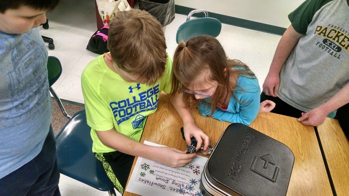 Tag students working together to solve a BreakoutEdu puzzle.